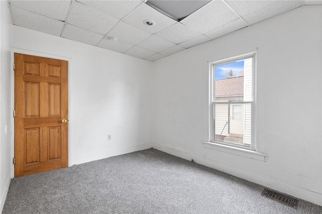 carpeted spare room with visible vents and a paneled ceiling