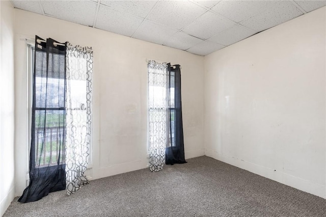 carpeted spare room with a drop ceiling