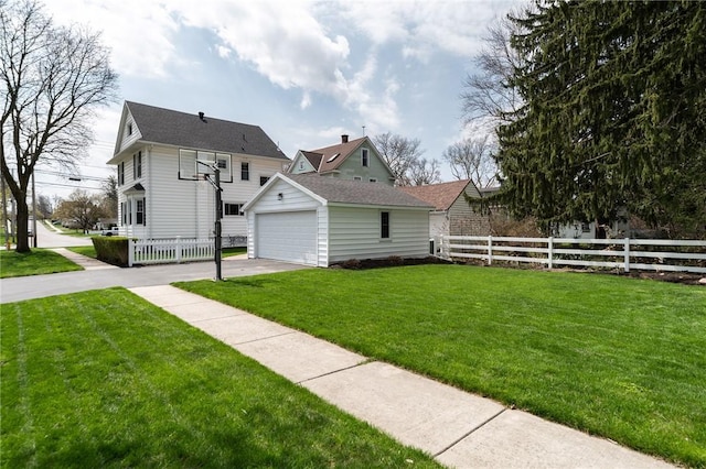 view of home's exterior featuring a lawn, driveway, fence, and an outdoor structure