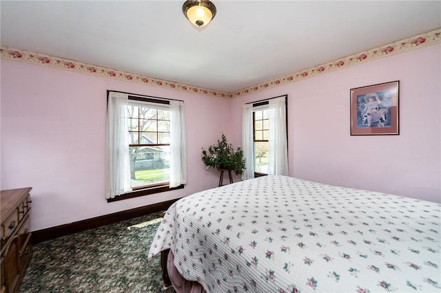 carpeted bedroom with baseboards and multiple windows