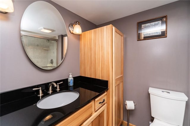 bathroom with vanity, a shower with door, and toilet