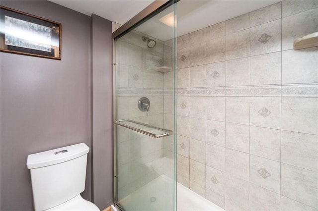 full bathroom featuring toilet and a shower stall
