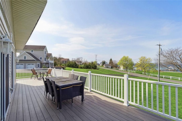 wooden deck with a lawn and outdoor dining area