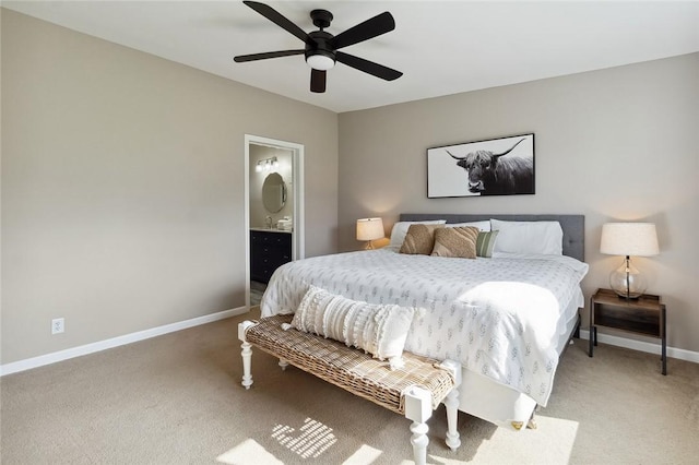 carpeted bedroom featuring baseboards, ensuite bathroom, and ceiling fan