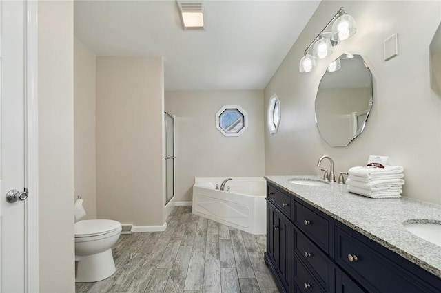 full bath with wood finished floors, toilet, a bath, a shower stall, and a sink