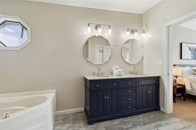 ensuite bathroom with double vanity, a sink, connected bathroom, and a garden tub