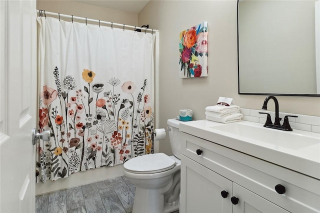 bathroom featuring vanity, wood finished floors, and toilet