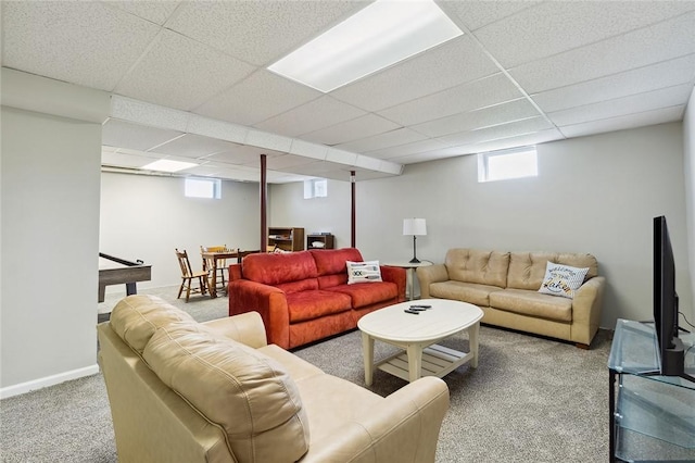 carpeted living area with baseboards and a paneled ceiling