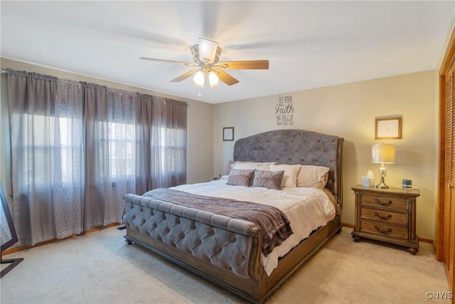 bedroom featuring ceiling fan, light carpet, and a closet