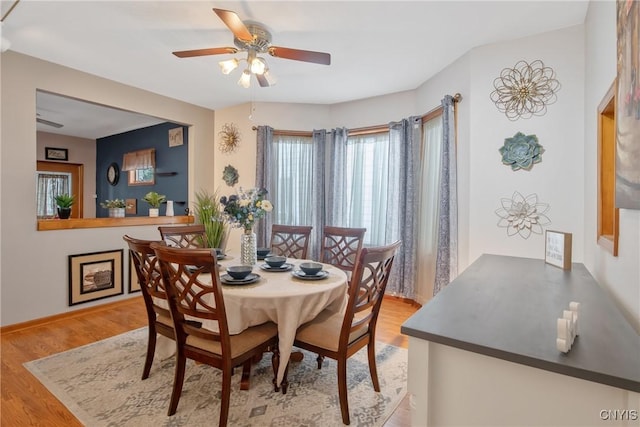dining room featuring a ceiling fan, baseboards, and wood finished floors