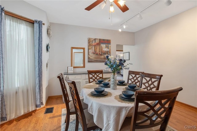 dining space featuring a ceiling fan, visible vents, track lighting, and light wood-style flooring