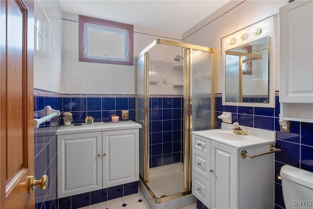 full bathroom featuring vanity, tile walls, a shower stall, and plenty of natural light