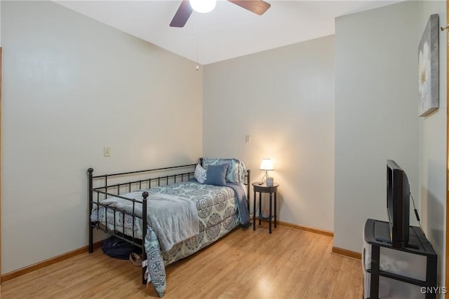 bedroom with baseboards, ceiling fan, and light wood finished floors