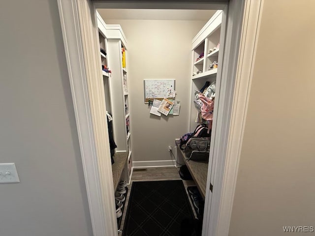 mudroom featuring baseboards and dark wood-style floors