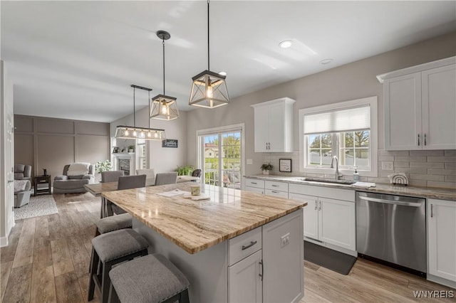 kitchen featuring plenty of natural light, a center island, a sink, and dishwasher