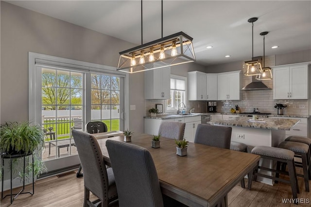 dining room featuring recessed lighting, light wood-type flooring, and a notable chandelier