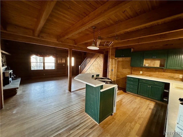 kitchen with wooden walls, wooden ceiling, green cabinetry, and beam ceiling