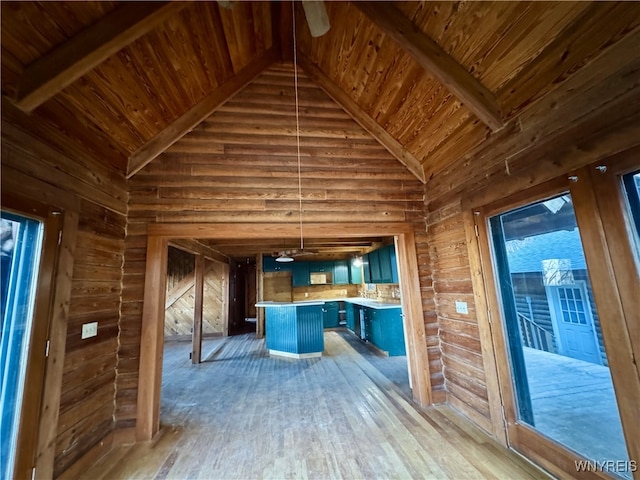 kitchen featuring wood ceiling, a center island, hardwood / wood-style flooring, and high vaulted ceiling