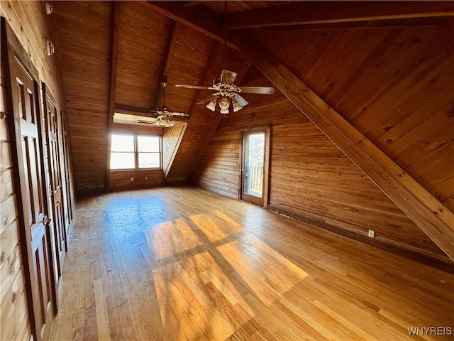 bonus room with wood walls, a ceiling fan, wooden ceiling, vaulted ceiling with beams, and wood finished floors