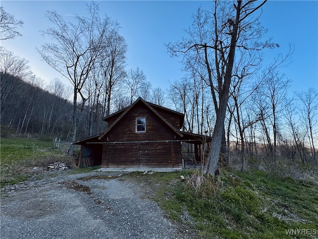 view of side of home featuring a barn and an outdoor structure