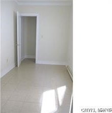 unfurnished room with baseboards and tile patterned floors