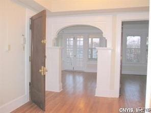 entryway featuring arched walkways and wood finished floors