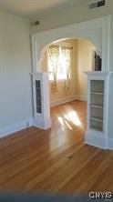 interior space with baseboards, visible vents, and wood finished floors