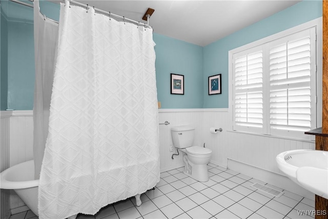 bathroom featuring visible vents, tile patterned flooring, wainscoting, toilet, and a shower with shower curtain