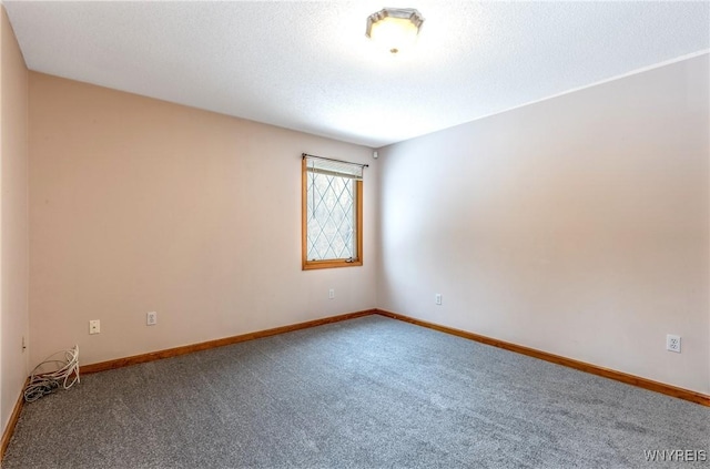 carpeted empty room featuring baseboards