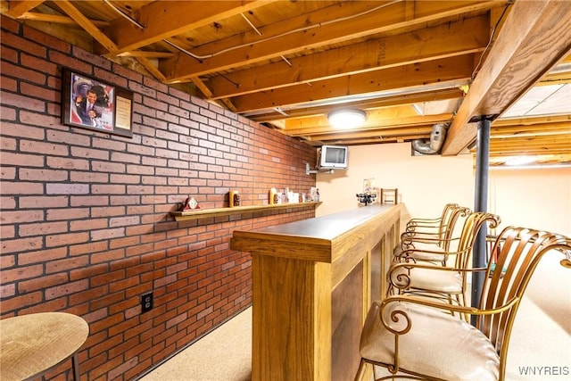 bar featuring brick wall, a bar, and carpet