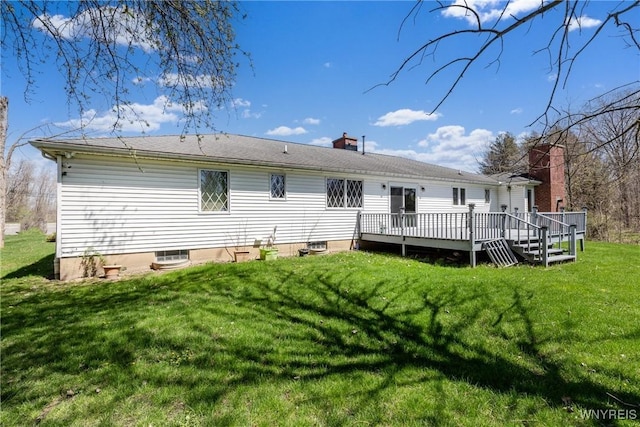 back of property with a yard, a wooden deck, and a chimney