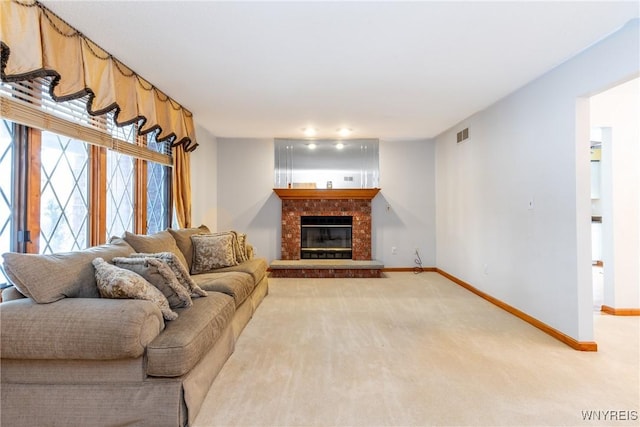 living area with light colored carpet, baseboards, a brick fireplace, and visible vents