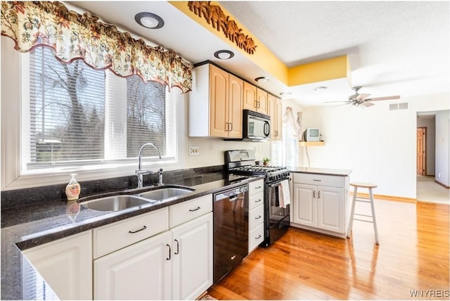 kitchen featuring black microwave, a sink, dishwasher, gas range, and visible vents