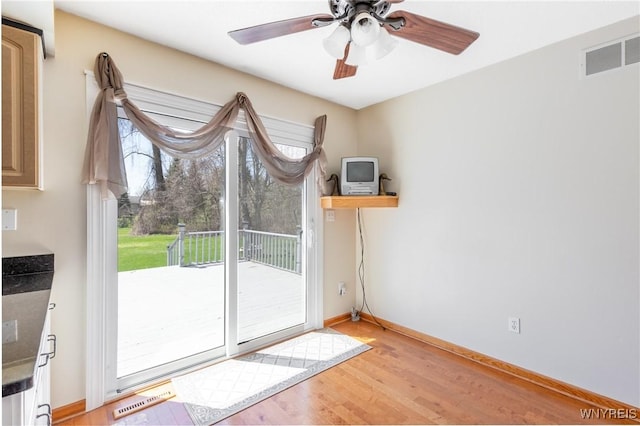 doorway to outside with visible vents, light wood-style floors, baseboards, and a wealth of natural light