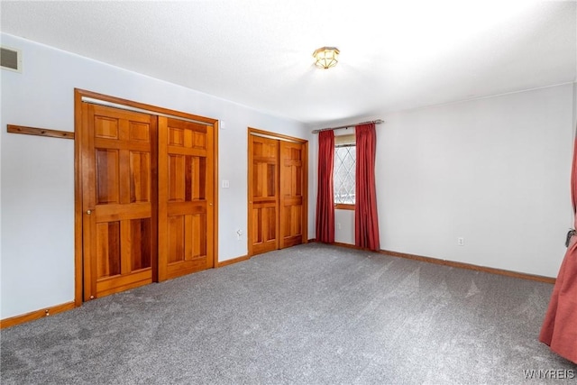 unfurnished bedroom with carpet floors, baseboards, and visible vents