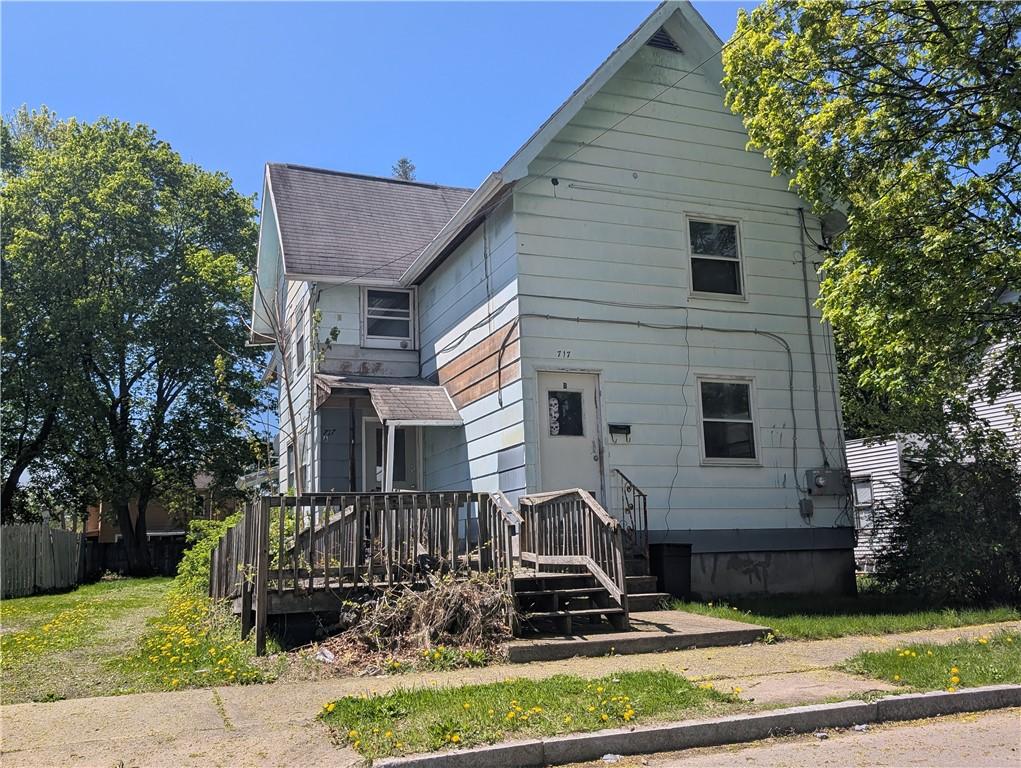 back of property featuring fence and roof with shingles
