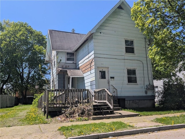 back of property featuring fence and roof with shingles