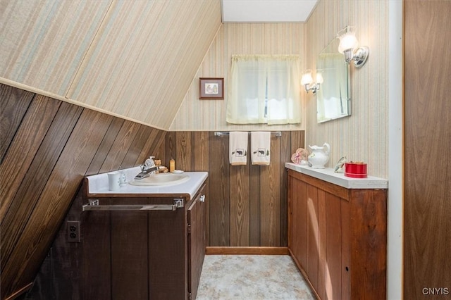 bathroom featuring vanity, wooden walls, and wallpapered walls