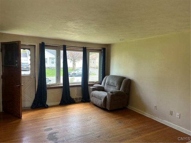 living area featuring baseboards and light wood-style floors