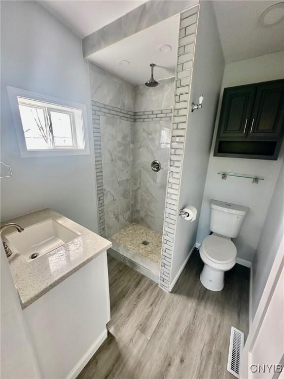 4850 Palmer Rd, Lee, NY 13471 - bathroom featuring visible vents, wood finished floors, toilet, and tiled shower