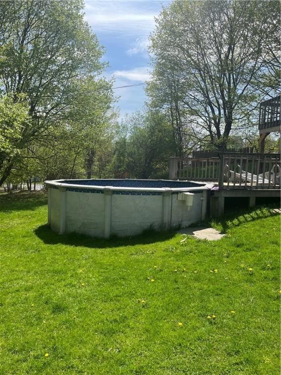 view of yard featuring an outdoor pool and a deck