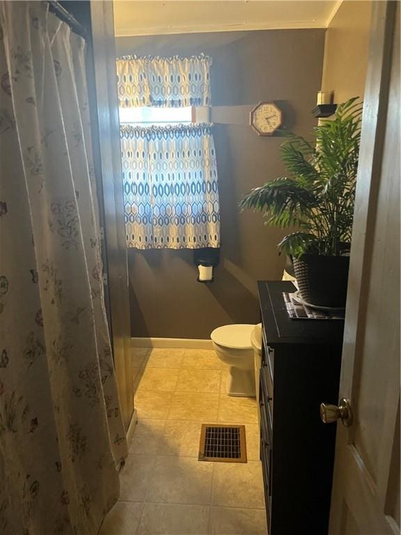 bathroom featuring visible vents, vanity, toilet, a shower with shower curtain, and tile patterned floors