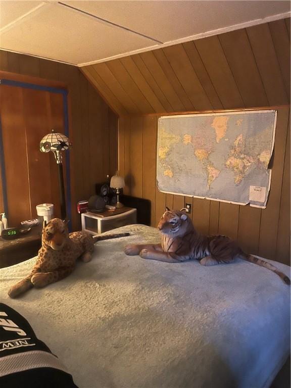 carpeted bedroom with wood walls and vaulted ceiling
