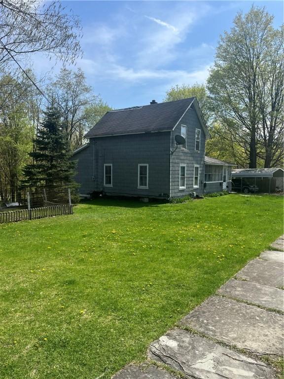 view of side of home with a yard