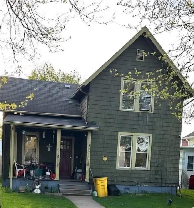 rear view of property with covered porch and a yard
