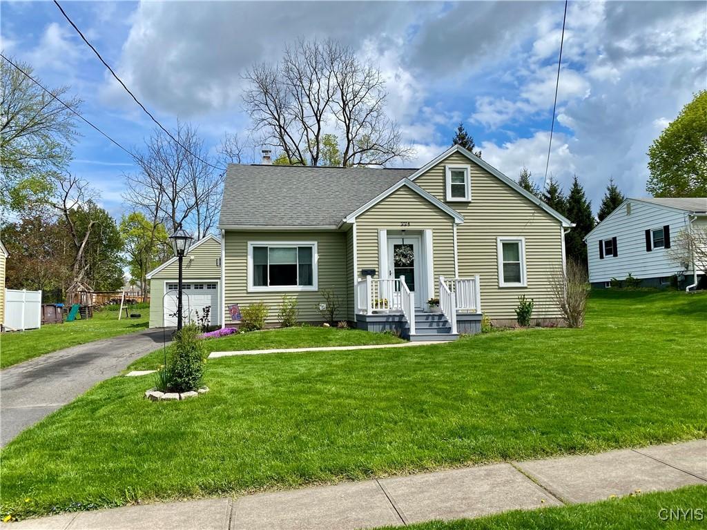 bungalow-style home with a shingled roof, a front yard, and aphalt driveway