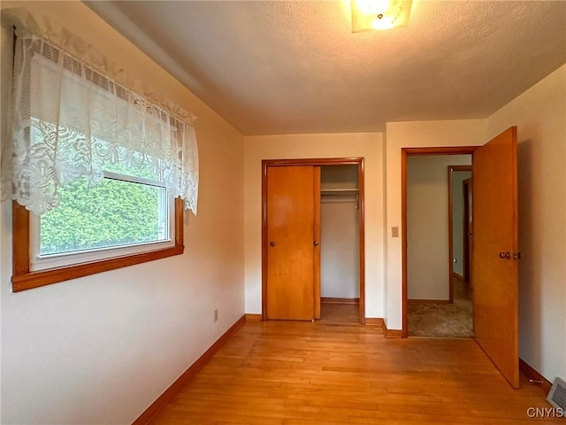 28 Concord Blvd, New Hartford, NY 13413 - unfurnished bedroom featuring a textured ceiling, visible vents, baseboards, a closet, and light wood-style flooring
