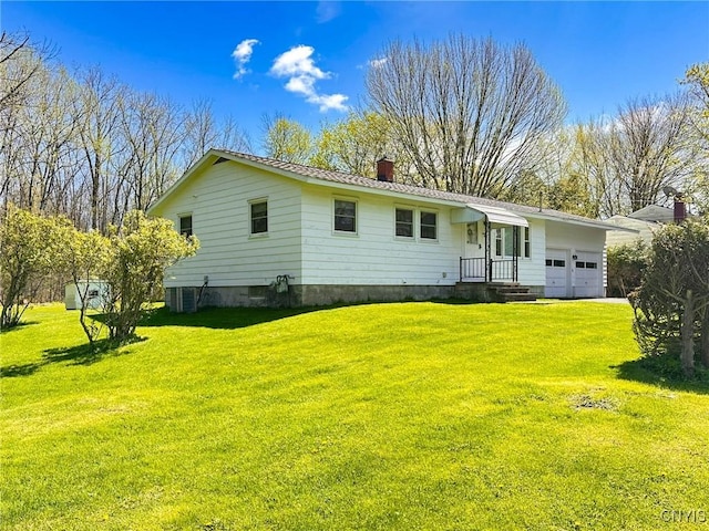 28 Concord Blvd, New Hartford, NY 13413 - rear view of property featuring a garage, a chimney, and a yard