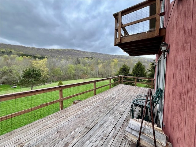 deck featuring a yard and a view of trees