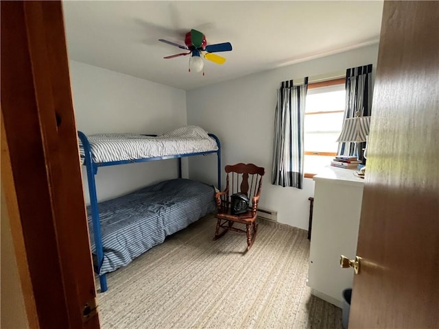 carpeted bedroom with a baseboard radiator and ceiling fan